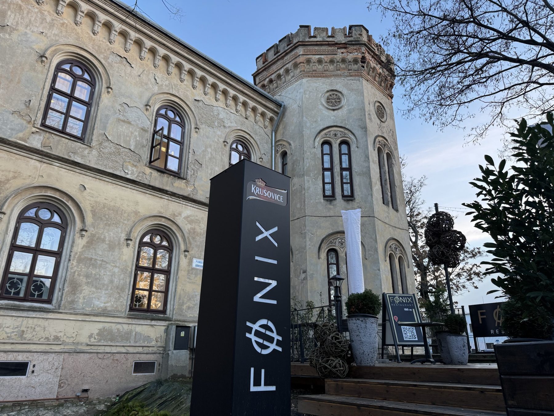 Novorománska budova Dôstojníckeho pavilónu v Komárne so vstupnou tabuľou Főnix